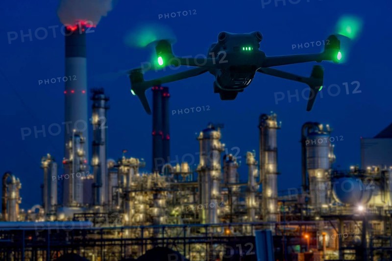 Symbolic image, photomontage, reconnaissance, spying with drones in industrial plants, critical infrastructure, drone flies towards an industrial complex, chemical plant, spying by camera drones