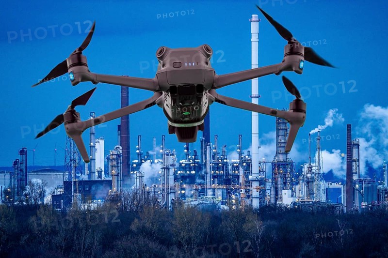 Symbolic image, photomontage, reconnaissance, spying with drones in industrial plants, critical infrastructure, drone flies towards an industrial complex, chemical plant, spying by camera drones