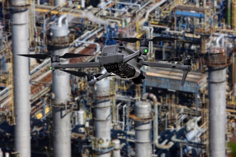 Symbolic image, photomontage, reconnaissance, spying with drones in industrial plants, critical infrastructure, drone flies towards an industrial complex, chemical plant, spying by camera drones