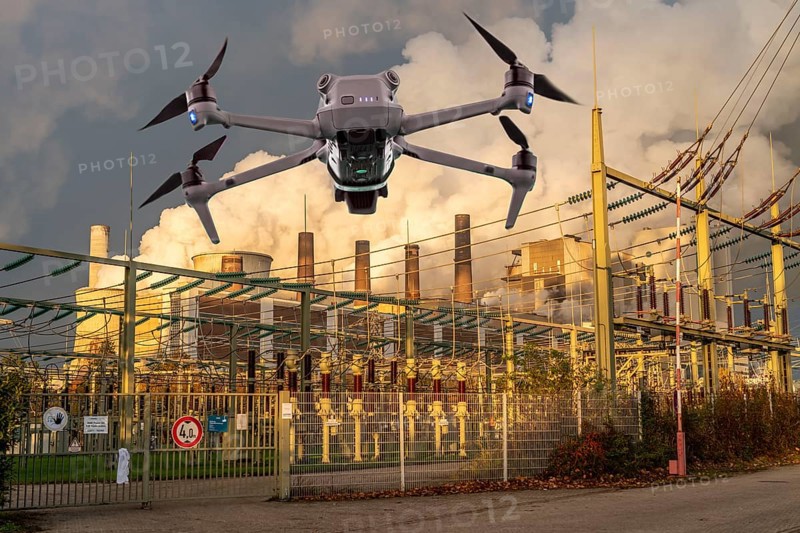 Symbolic image, photomontage, reconnaissance, spying with drones in industrial plants, critical infrastructure, drone flies towards an industrial complex, power plant, substation, spying by camera drones