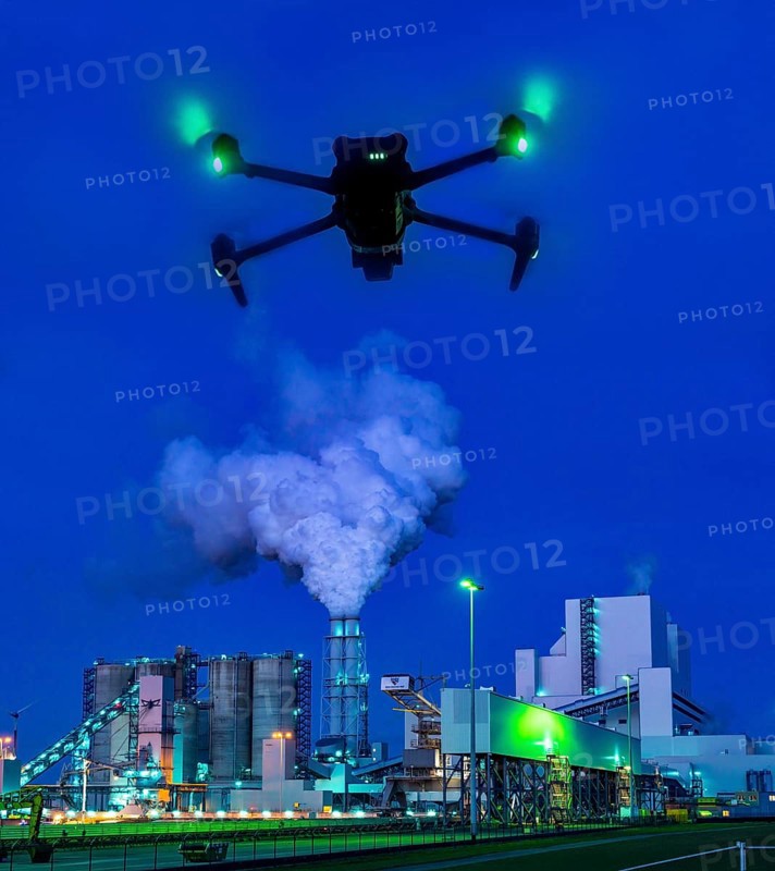 Symbolic image, photomontage, reconnaissance, spying with drones in industrial plants, critical infrastructure, drone flies towards an industrial complex, power plant, spying by camera drones