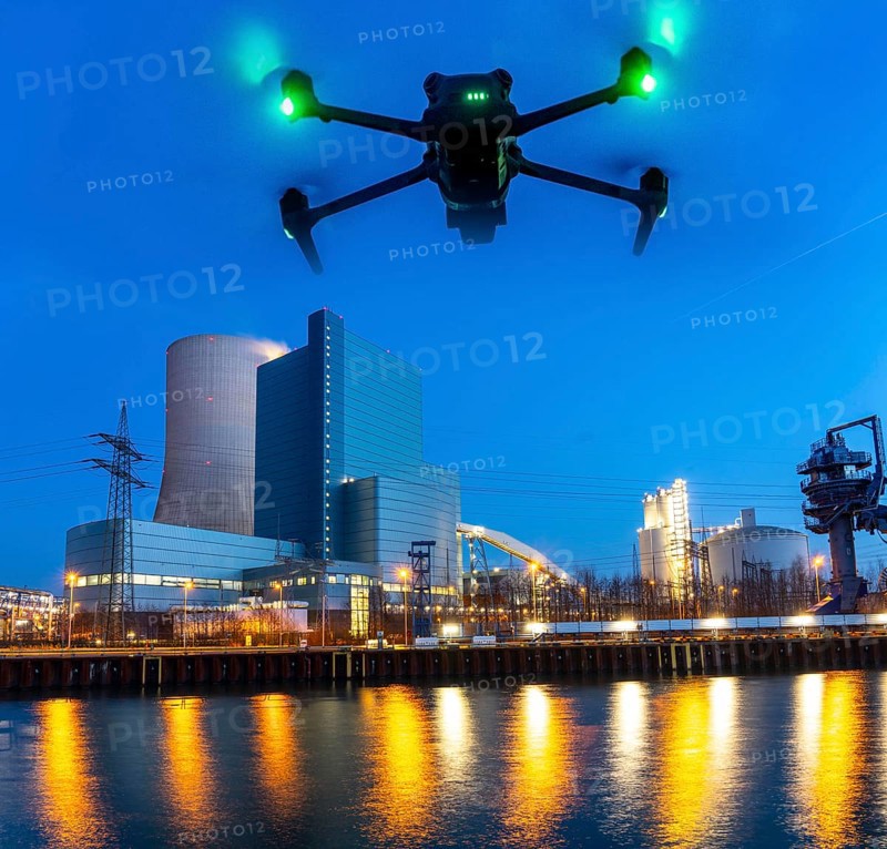 Symbolic image, photomontage, reconnaissance, spying with drones in industrial plants, critical infrastructure, drone flies towards an industrial complex, power plant, spying by camera drones