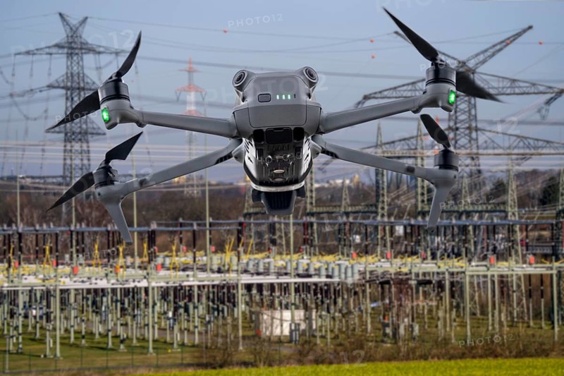 Symbolic image, photomontage, reconnaissance, spying with drones in industrial plants, critical infrastructure, drone flies towards an industrial complex, power plant, spying by camera drones