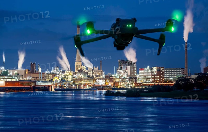 Symbolic image, photomontage, reconnaissance, spying with drones in industrial plants, critical infrastructure, drone flies towards an industrial complex, chemical plant, spying by camera drones
