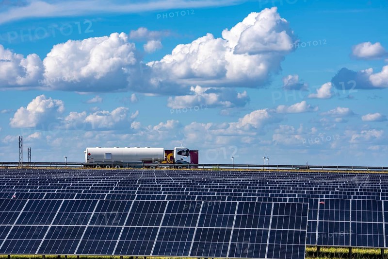 86, 5 MW peak ground-mounted photovoltaic systems, by RWE, with over 141, 000 solar modules, on a verge, over 1 km long, along the A44 motorway near Bedburg, at the Jackerath junction, recultivated open-cast mining site, field with sunflowers, North Rhine-Westphalia, Germany