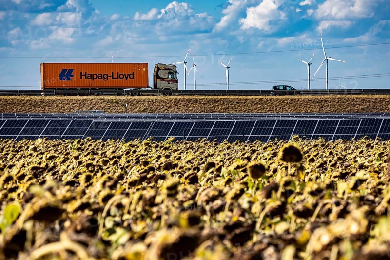 86, 5 MW peak ground-mounted photovoltaic systems, by RWE, with over 141, 000 solar modules, on a verge, over 1 km long, along the A44 motorway near Bedburg, at the Jackerath junction, recultivated open-cast mining site, field with sunflowers, North Rhine-Westphalia, Germany