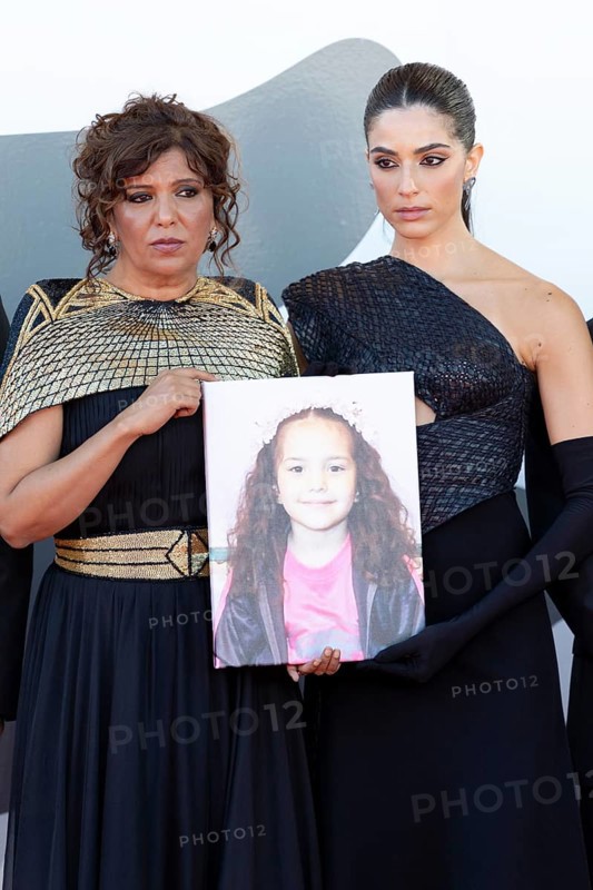 Venice, Italy - 3 September 2025: Kaouther Ben Hania, Saja Kilani with a portrait of the five-year-old Palestinian girl Hind Rajab, who was killed by the Israeli army in the Gaza Strip in January 2024, during the red carpet of - The Voice Of Hind Rajab - during the 82nd Venice International Film Festival