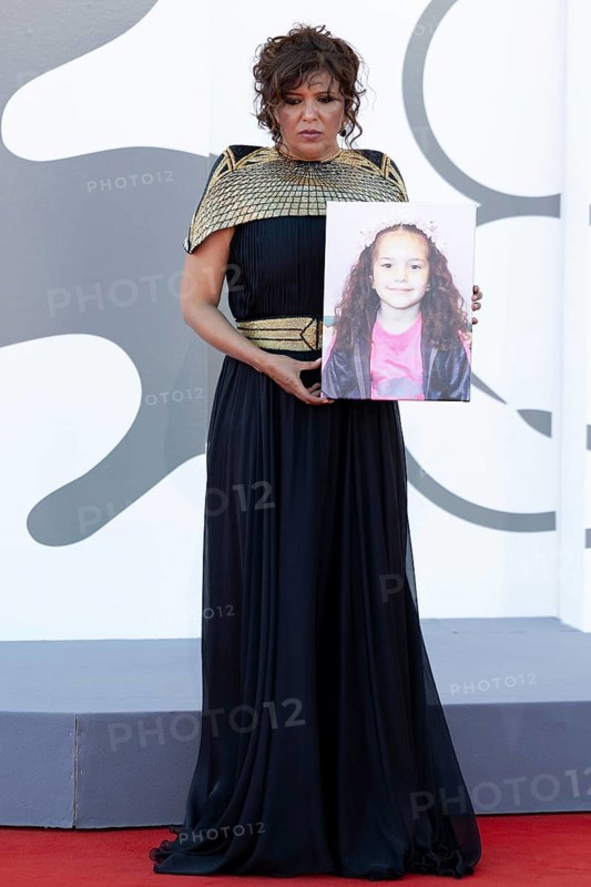 Venice, Italy - 3 September 2025: Kaouther Ben Hania with a portrait of five-year-old Palestinian girl Hind Rajab, who was killed by the Israeli army in the Gaza Strip in January 2024, during the red carpet of - The Voice Of Hind Rajab - during the 82nd Venice International Film Festival
