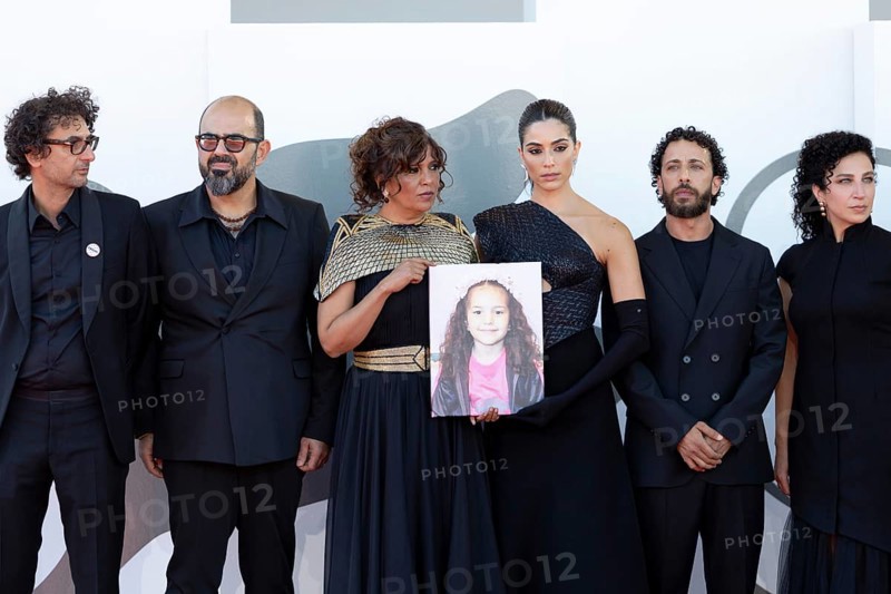 Venice, Italy - 3 September 2025: Nadim Cheikhrouha, Amer Hlehel, Kaouther Ben Hania, Saja Kilani, Motaz Malhees, Clara Khoury, with a portrait of five-year-old Palestinian girl Hind Rajab, who was killed by the Israeli army in the Gaza Strip in January 2024, during the Red Carpet of - The Voice Of Hind Rajab - during the 82nd Venice International Film Festival