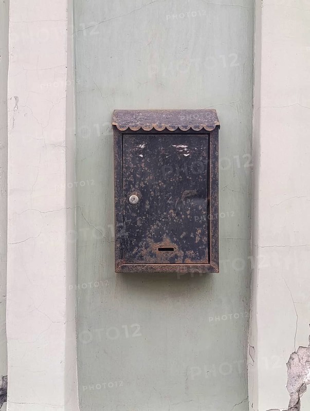 Old metal mailbox hanging on the wall of the house, copy space