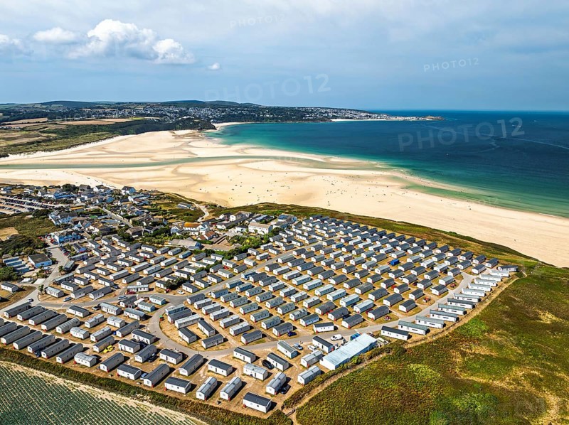 Holiday homes over Hayle Beach and Hayle Estuary from drone, St Ives Bay, Cornwall, England, United Kingdom