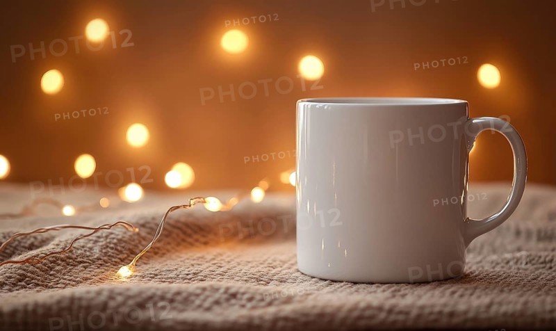 A white coffee cup sits on a blanket with a light shining on it. The light creates a warm and cozy atmosphere, perfect for enjoying a hot cup of coffee on a chilly day. AI generated