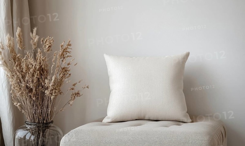 A white pillow sits on a bench next to a vase of dried flowers. The pillow is unmade and the flowers are brown. The scene is simple and peaceful, with the pillow and flowers creating a sense of calm. AI generated