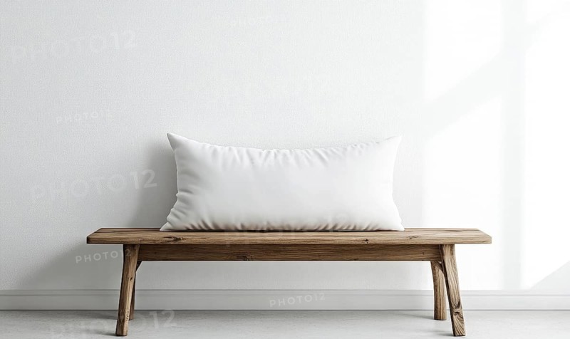 A minimalist wooden bench with a white pillow, bathed in natural light. AI generated