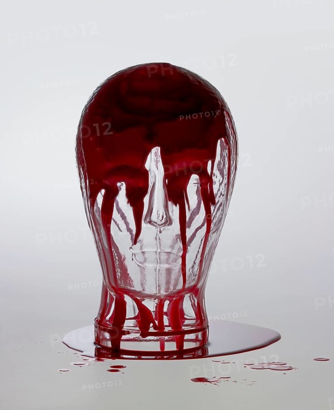 Generic human dummy head made of glass, overwhelmed with red fluid in light grey back