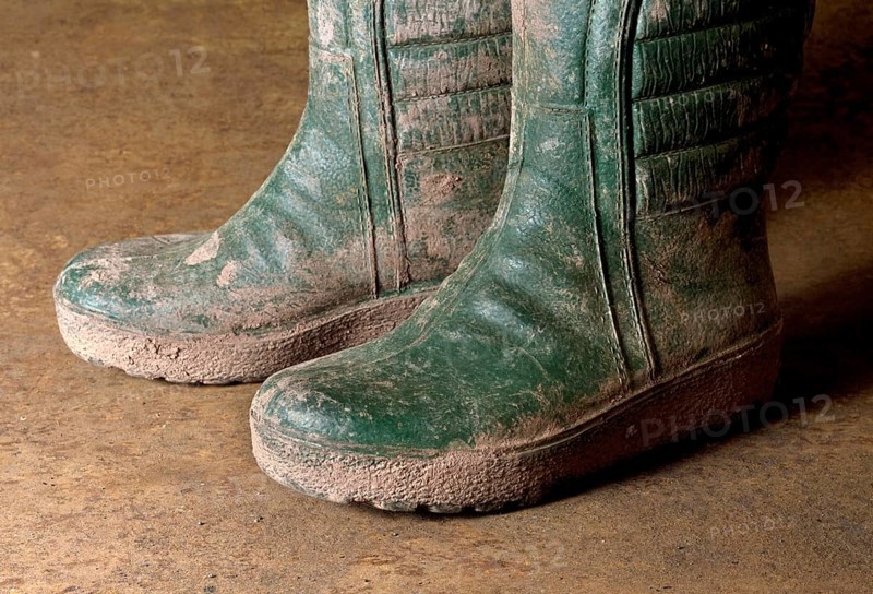 Pair of green dirty gumboots in rusty back