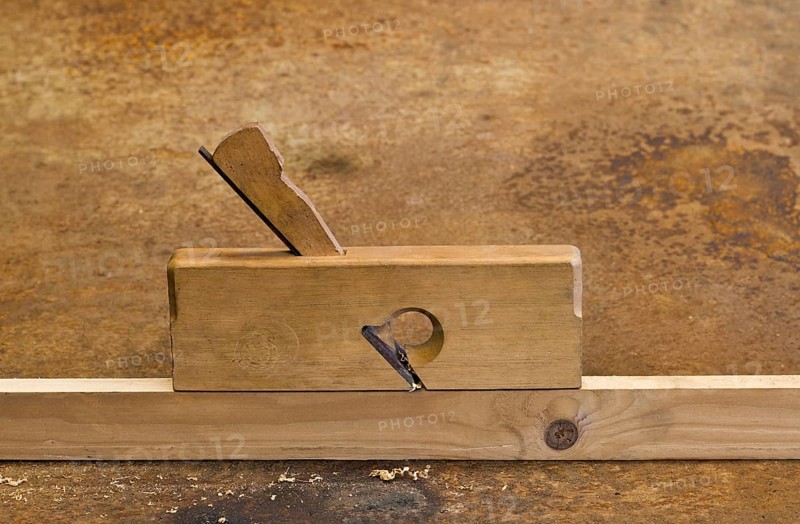 Old planer on wooden plank