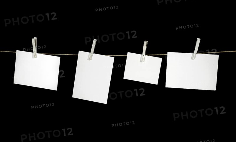Clothesline with some white labels fixed with clothes pins in black back