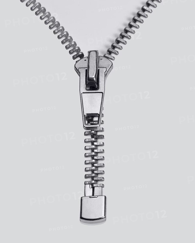 Studio photography of a long zipper half closed, in light back