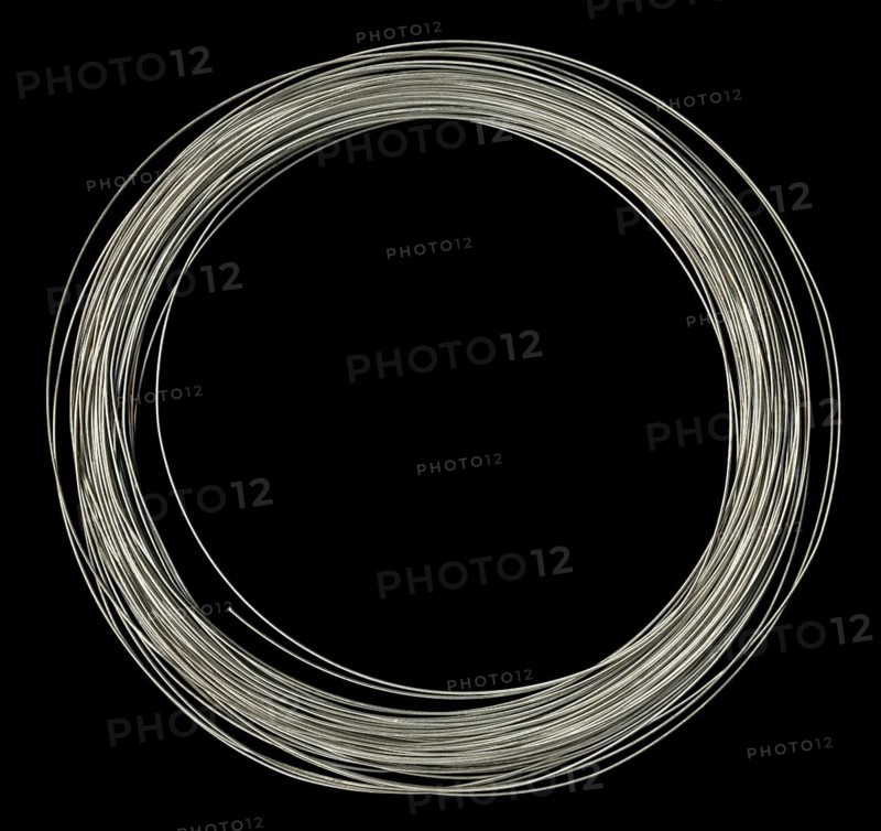 Studio photography of rolled silver wire in black back