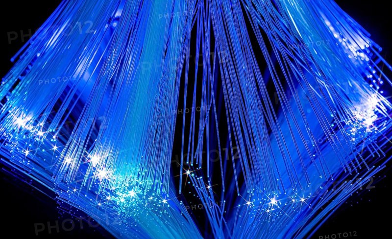 Blue illuminated optical fiber closeup in black back