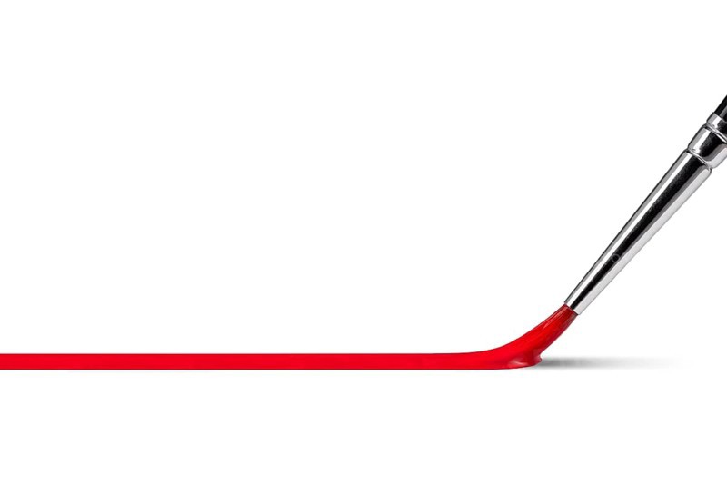 Art and craft theme showing a paintbrush while painting a red line of paint in white back