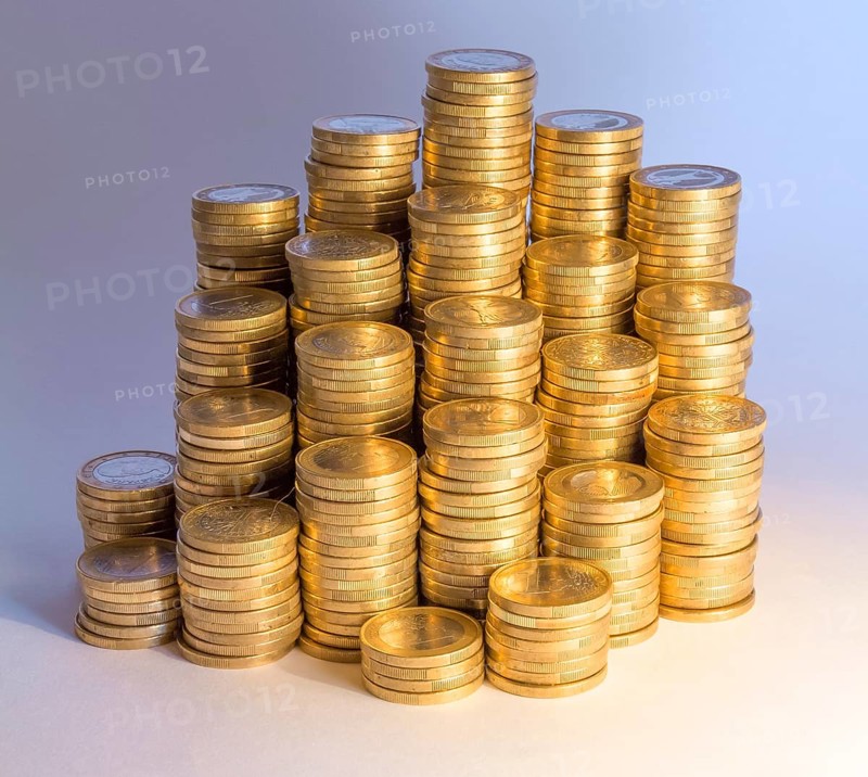 Lots of stacked 1 euro coins incolorful illuminated ambiance