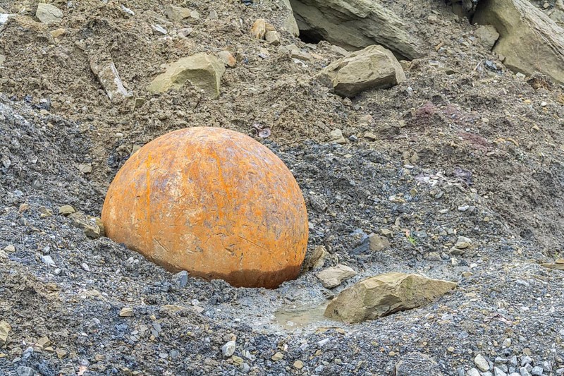 Rusty metal ball used for stone crushing in stony back