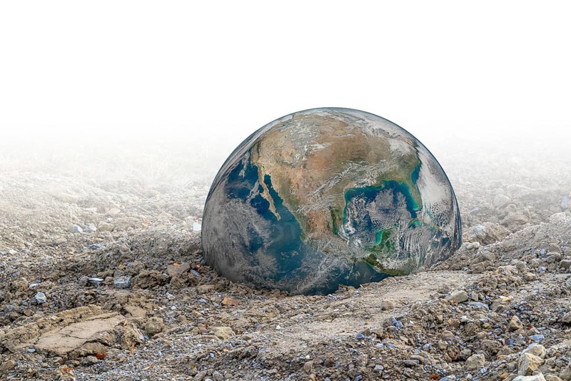 Big rusty metal ball in gradient gravel back