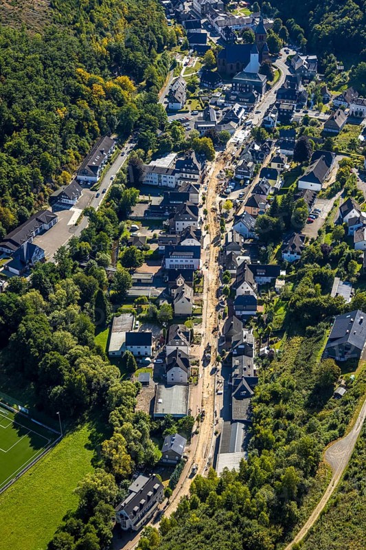 Aerial view, Hundemstraße road works with closure, residential area and above the St.Peter and Paul parish church, Kirchhundem, Sauerland, North Rhine-Westphalia, Germany, place of worship, construction work, construction area, building site, building plots, construction project, construction site, DE, Europe, football, football pitch, football stadium, religious community, place of worship, property tax, holy place, real estate, church, parish, denomination, aerial view, aerial photography, aerial photography, new building, religion, religious site, sport, sports facility, sports field, tennis, tennis facility, tennis court, tennis courts, tennis club, overview, bird's-eye view, residential area, living and life, residential area, quality of life, residential neighbourhood, housing estate, residential district, birds-eyes view, overview