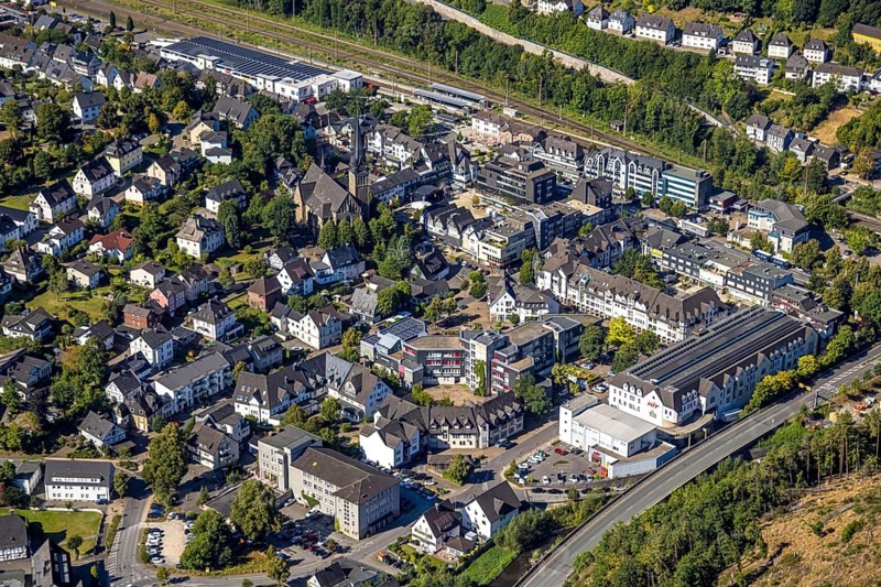 Aerial view, residential area Altenhundem with town hall Thomas-Morus-Platz, police station Bürgermeister-Beckmann-Platz, catholic parish church St. Agatha and market square, Lennestadt-Altenhundem railway station, HIT supermarket and Aldi supermarket above, Altenhundem, Lennestadt, Sauerland, North Rhine-Westphalia, Germany, place of worship, railway premises, railway station, platform, authority, community centre, DE, Deutsche Bahn AG, shopping centre, shopping markets, shopping square, shopping centre, Europe, religious community, railway tracks, tracks, house of worship, holy place, church, parish, Kirchhundem, denomination, aerial view, aerial photography, aerial photography, local supply centre, police, police station, police station, town hall, religion, religious site, shopping centre, state authority, state power, city administration, overview, bird's-eye view, overview
