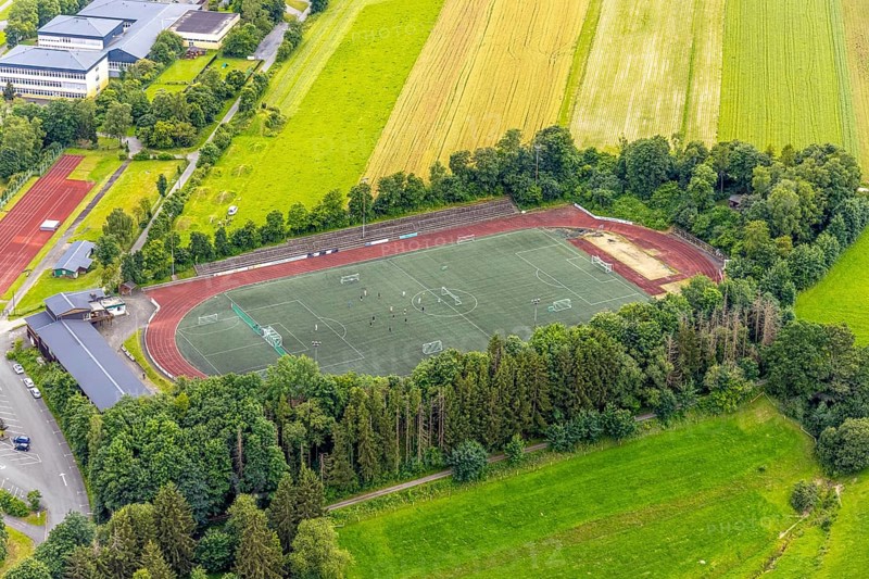 Aerial view, football stadium athletics stadium Auf dem Stöppel, sports field Bad Berleburg, youth players on the field, Bad Berleburg, Wittgensteiner Land, North Rhine-Westphalia, Germany, architecture, athletes, outdoor shot, building, field, leisure, football, football stadium, green area, sky, youth, youth players, landscape, athletics, athletics stadium, team sport, summer, playing field, sport, sports field, sports event, stadium, day, training, stands, competition, competition, rural