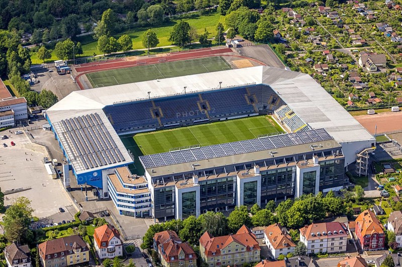 Aerial view, football stadium SchücoArena of DSC Arminia Bielefeld, also Almstadion or Bielefelder Alm, solar roof, centre, Bielefeld, East Westphalia, North Rhine-Westphalia, Germany, football stadium, SchücoArena, DSC Arminia Bielefeld, Almstadion, Bielefelder Alm, sports facility, architecture, stadium, solar system, outdoor, aerial view, daylight, urban, infrastructure, football, sport, green, field, seats, capacity, leisure, venue, technology, renewable energy, arena, venue, city, landscape, building
