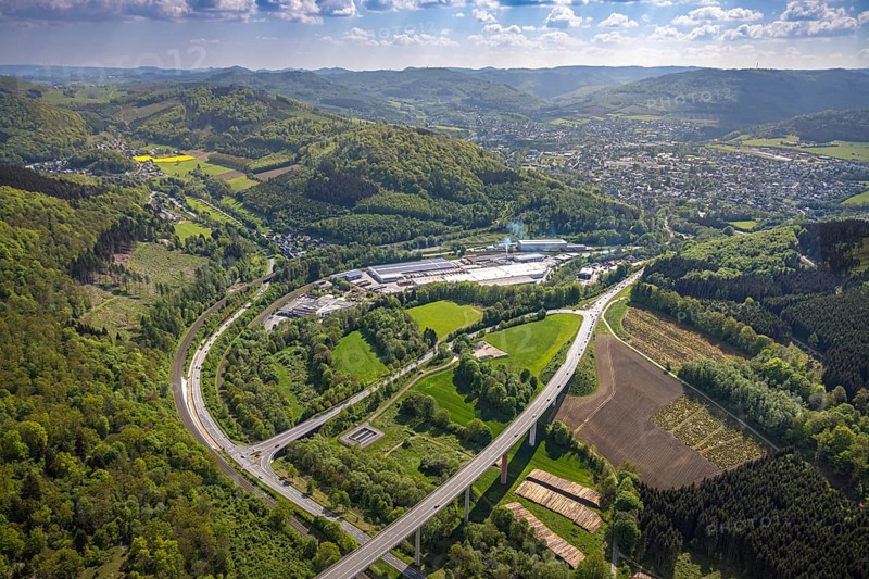 Aerial view, Ruhr valley bridge Bermecke over the river Ruhr, exit of the federal road B480n onto the main road B7, tree plantations and timber yard, industrial area with Mayr Meinhof Holz, forest area, left district Antfeld, right view to Olsberg, distant view with mountain range, Nuttlar, Bestwig, Sauerland, North Rhine-Westphalia, Germany, Ruhr valley bridge Bermecke, Ruhr river, exit, federal road B480n, main road B7, tree plantations, timber yard, industrial area, Mayr Meinhof Holz, Antfeld district, view to Olsberg, distant view, mountain range, bridge, infrastructure, traffic, nature, landscape, industry, wood processing, road course, rural, panoramic view, region, connecting road, natural resources, horizon