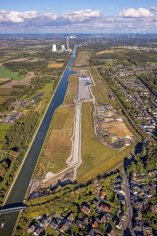 Aerial view, Wasserstadt Aden on the Datteln-Hamm Canal, construction area for planned urban quarter on the site of the former Haus Aden colliery, behind the Bergkamen power station, distant view and blue sky with clouds, Oberaden, Bergkamen, Ruhr area, North Rhine-Westphalia, Germany, architecture, construction work, construction area, construction site, Datteln-Hamm canal, distant view, building, terrain, Haus Aden, sky, industry, industrial area, infrastructure, canal, Bergkamen power station, landscape, perspective, planning, region, urban development, transformation, urban, Wasserstadt Aden, clouds, blue sky, former colliery, planned urban quarter