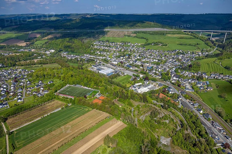 Aerial view, residential area, local view district Nuttlar with motorway A46 valley bridge Nuttlar, mountain range in the background, sports field and tennis courts Ostwig, Nuttlar, Bestwig, Sauerland, North Rhine-Westphalia, Germany, residential area, local view, district, motorway, A46, valley bridge, mountain range, background, sports field, tennis courts, Ostwig, infrastructure, traffic, bridge, mountains, landscape, settlement, environment, district, buildings, houses, football field, recreation, leisure, street, motorway bridge, residential area, greenery, aerial view, panorama, region