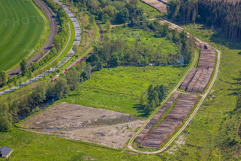 Aerial view, timber wet storage site temporary storage, S-Bahn railway line, road Am Dümel, Ostwig, Bestwig, Sauerland, North Rhine-Westphalia, Germany, timber wet storage, temporary storage, S-Bahn railway line, road, Am Dümel, infrastructure, transport, rail traffic, timber, storage site, industry, logistics, rural, scenic, village, traffic, overview, forest, nature, trade, trees, buildings, tracks