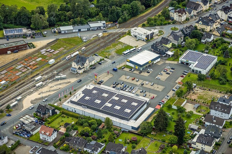 Aerial view, Bahnhofstrasse shopping centre with Rewe supermarket and solar roof, Takko fashion and K+K shoes, Bad Laasphe railway station and station building, new police station, Bad Laasphe, Wittgensteiner Land, North Rhine-Westphalia, Germany, architecture, railway station, station building, Bahnhofstrasse, drone shot, shopping district, shopping centre, retail, energy, development, building, shops, infrastructure, K+K shoes, sustainability, new building, perspective, police station, Rewe supermarket, solar system, solar roof, city, urban, Takko Fashion, transport links, renewable energies, modern, urban landscape, public space