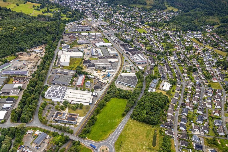 Aerial view, commercial area in the floodplain, roundabout Bahnhofstraße federal road, B62, residential area around Thüringer Weg and Hirtsgrunder Weg, Bad Laasphe, Wittgensteiner Land, North Rhine-Westphalia, Germany, architecture, drive, Bahnhofstraße, federal road, Europe, building, commercial area, Hirtsgrunder Weg, industry, infrastructure, roundabout, landscape, planning, region, settlement, town, urban development, road network, structure, Thüringer Weg, urban, traffic routes, residential area, residential buildings, civilisation, overview