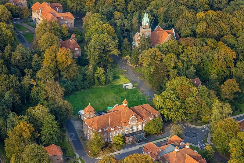 Aerial view, LVR Clinic, House of Economic Administration and Kitchen at Buchenweg roundabout, LVR Clinic Church, autumnal forest, Hau, Bedburg-Hau, Lower Rhine, North Rhine-Westphalia, Germany, architecture, exterior view, Buchenweg, trees, building, health care, autumn colours, infrastructure, institution, season, church, hospital, roundabout, culture, kitchen, landscape, foliage, aerial perspective, nature, region, religion, cityscape, urban planning, environment, forest, economic administration, European, autumnal, vegetation, public