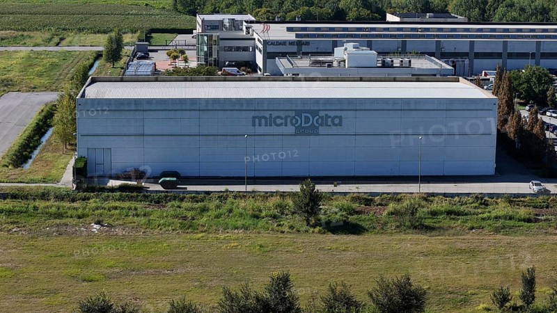 Cremona, Italy August 22nd 2025 Aerial view revealing MicroData Group headquarters, massive data center nestled among verdant landscape and industrial infrastructure