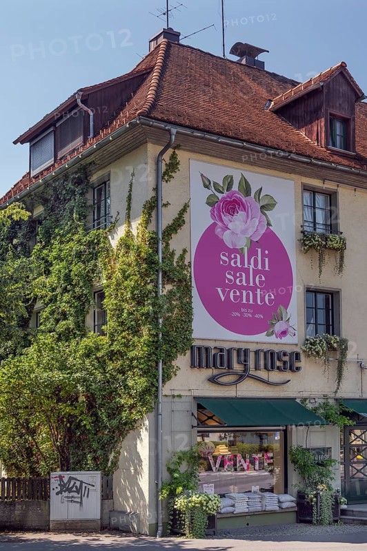 Overgrown façade with floral decorations and advertising poster, Dornbirn, Vorarlberg, Austria