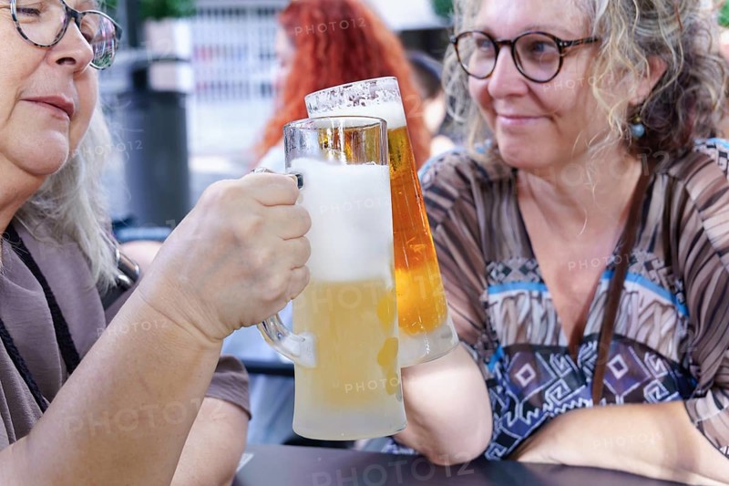 Women enjoying refreshing beer at a pub, celebrating friendship