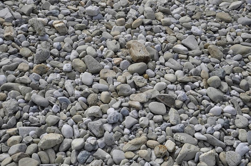 Pebbles background on a beach, A close-up view of a surface covered with various shapes and sizes of smooth pebbles and rocks, Old house seeing accross a window