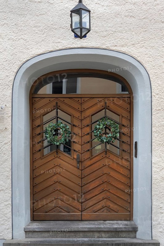 Façade with wooden gate, lantern and ivy wreaths, Kempten, Allgäu, Bavaria, Germany
