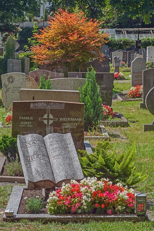 Gravesite with stone book and floral decoration, catholic cemetery, Kempten, Allgäu, Bavaria, Germany