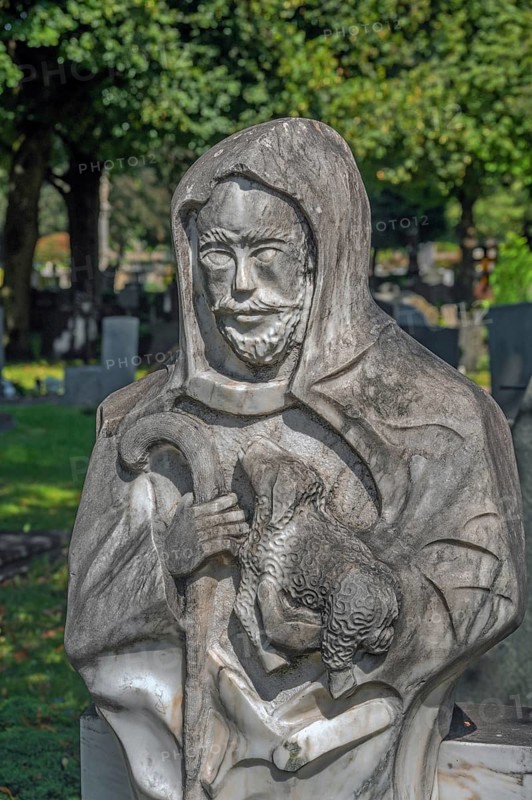 Gravesite with stone figure, the good shepherd with lamb catholic cemetery, Kempten, Allgäu, Bavaria, Germany
