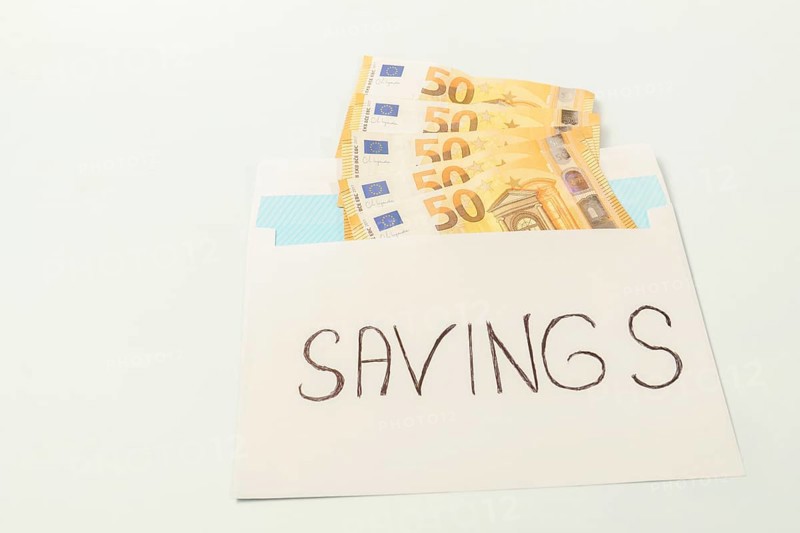 Euro banknotes in an envelope labeled savings illustrating the concept of personal finance and money management