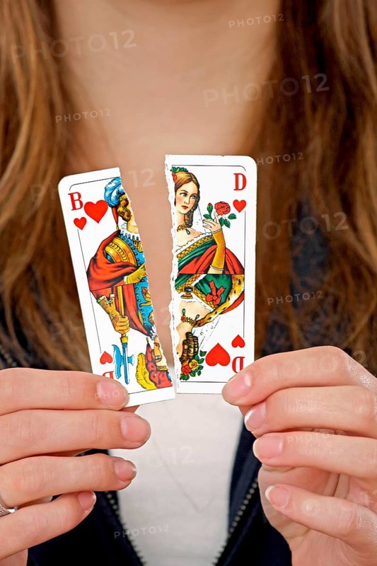 Woman holding a torn playing card in her hand