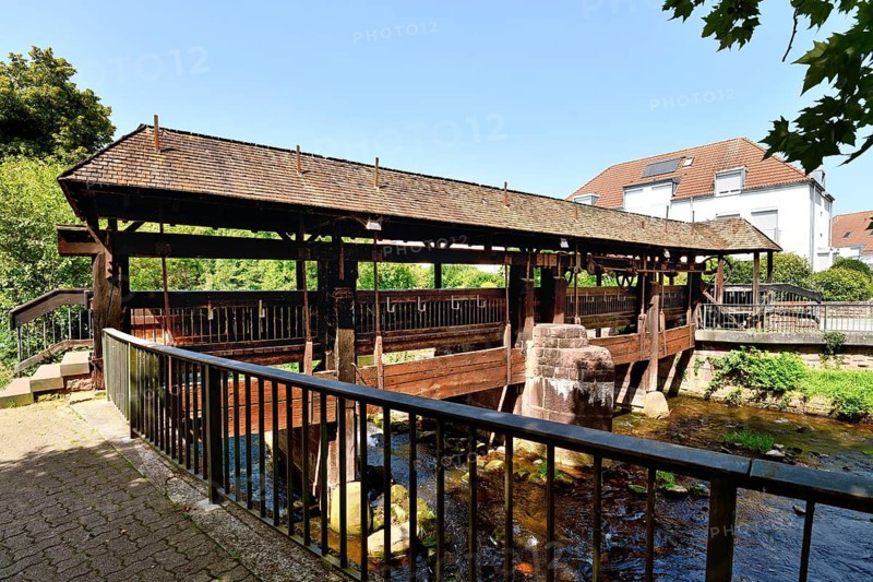 Ettlingen, Germany - August 13th 2025: Old wooden bridge over the Alb river. Historic landmark on a sunny day